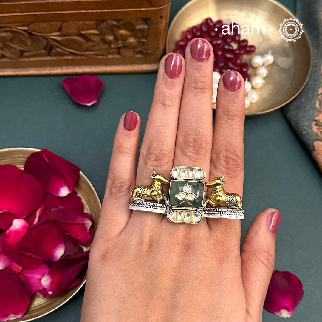 Experience the perfect blend of traditional and modern style with our Noori Two Tone Nandi Silver Ring. Crafted in 92.5 silver, adorned with intricate Nandi motifs and a sparkling stone inlay, this statement piece is enhanced with delicate kundan accents. Elevate any outfit with this unique and timeless ring.