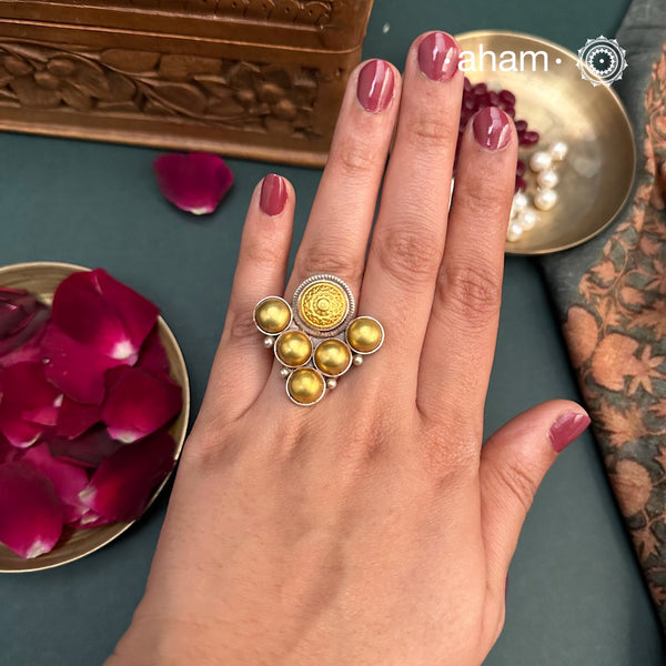 Enhance your style with the timeless elegance of the Two Tone Silver Ring. Handcrafted by skilled karigars in Barmer, Rajasthan, this ring features traditional Bandhel work, where a thin sheet of 22 carat hand beaten gold is set on silver using a unique wax filling technique. A classic representation of Indian craftsmanship.