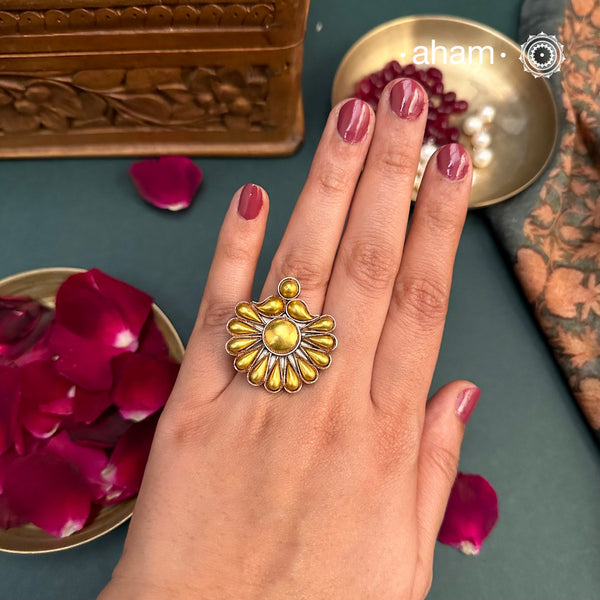 Enhance your style with the timeless elegance of the Two Tone Silver Ring. Handcrafted by skilled karigars in Barmer, Rajasthan, this ring features traditional Bandhel work, where a thin sheet of 22 carat hand beaten gold is set on silver using a unique wax filling technique. A classic representation of Indian craftsmanship.