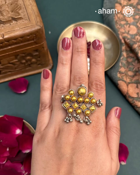 Enhance your style with the timeless elegance of the Two Tone Silver Ring. Handcrafted by skilled karigars in Barmer, Rajasthan, this ring features traditional Bandhel work, where a thin sheet of 22 carat hand beaten gold is set on silver using a unique wax filling technique. A classic representation of Indian craftsmanship.