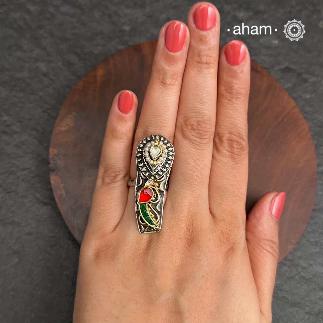 Noori two tone adjustable ring with Parrot motif. Handcrafted in 92.5 sterling silver with hints of gold polish, pearls and kundan work. Perfect to match your Indian or fusion outfit.
