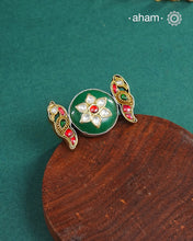 Noori two tone adjustable ring handcrafted in 92.5 sterling silver with green carved stone center and kundan peacocks on either sides. Perfect to match your Indian or fusion outfit. 