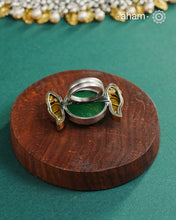 Noori two tone adjustable ring handcrafted in 92.5 sterling silver with green carved stone center and kundan peacocks on either sides. Perfect to match your Indian or fusion outfit. 