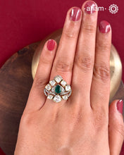 Crafted from 92.5% sterling silver with a rich gold polish, this ring showcases a captivating green emerald-like center stone. Surrounding it, moissanite stones add exceptional sparkle and brilliance, enhancing the ring’s luxurious appeal. Designed with precision, this piece offers a perfect blend of elegance and glamour for discerning jewellery enthusiasts.