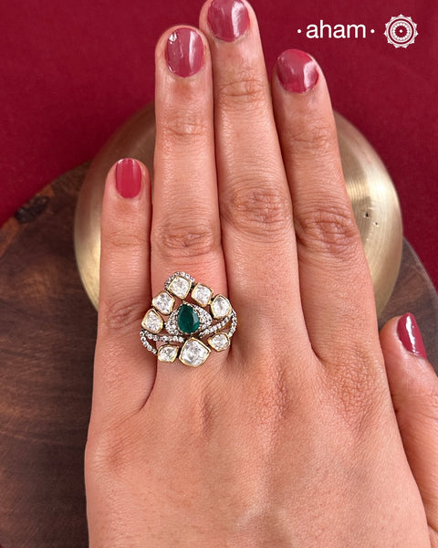 Crafted from 92.5% sterling silver with a rich gold polish, this ring showcases a captivating green emerald-like center stone. Surrounding it, moissanite stones add exceptional sparkle and brilliance, enhancing the ring’s luxurious appeal. Designed with precision, this piece offers a perfect blend of elegance and glamour for discerning jewellery enthusiasts.