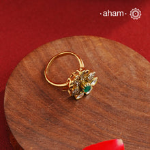 This exquisite ring features 92.5 sterling silver with a fine gold polish, showcasing a peacock motif that symbolizes elegance and grace. At its center lies a vibrant green emerald-like stone, surrounded by sparkling moissanite stones and delicate American diamonds, enhancing its brilliance. Expertly crafted, this piece combines traditional artistry with contemporary sparkle, making it a distinguished addition to any jewelry collection.
