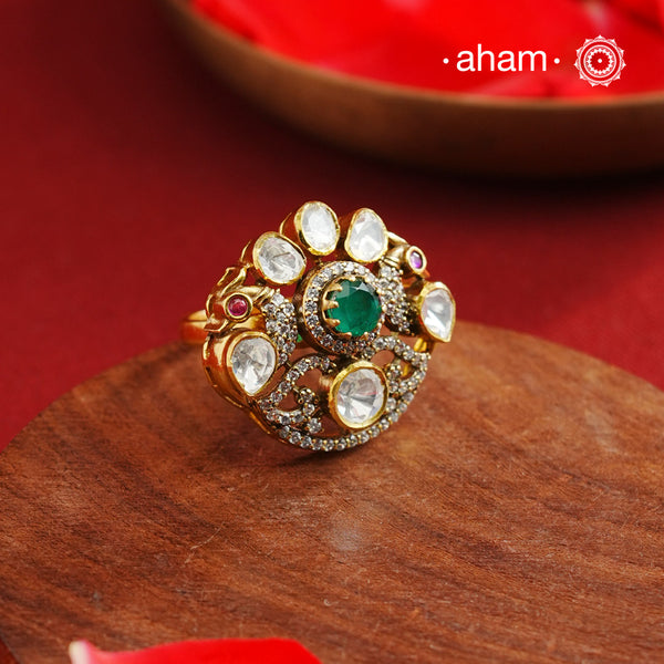 Crafted from 92.5% sterling silver with a rich gold polish, this ring showcases a captivating green emerald-like center stone. Surrounding it, moissanite stones add exceptional sparkle and brilliance, enhancing the ring’s luxurious appeal. Designed with precision, this piece offers a perfect blend of elegance and glamour for discerning jewellery enthusiasts.