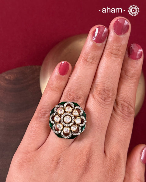 This exquisite ring features a dazzling moissanite center set within an elegant flower design, accented by deep green stones. Crafted from 92.5% sterling silver and enhanced with a refined gold polish, for a luxurious finish. Perfect for those seeking a sophisticated blend of classic craftsmanship and contemporary style.