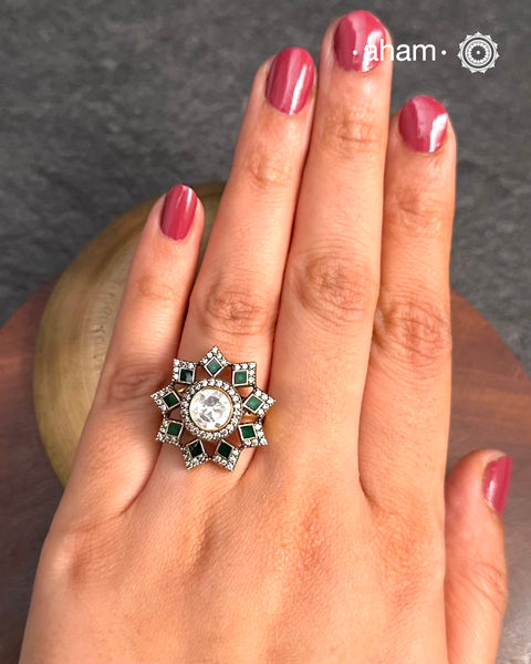 This exquisite ring features a dazzling moissanite ring with an elegant flower design, accented by green stones. Crafted from 92.5% sterling silver and enhanced with a refined gold polish, for a luxurious finish. Perfect for those seeking a sophisticated blend of classic craftsmanship and contemporary style.