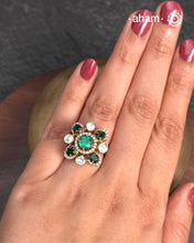 This exquisite ring features dazzling moissanite stones set within an elegant flower design, accented by green stones. Crafted from 92.5% sterling silver and enhanced with a refined gold polish, for a luxurious finish. Perfect for those seeking a sophisticated blend of classic craftsmanship and contemporary style.