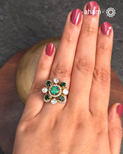 This exquisite ring features dazzling moissanite stones set within an elegant flower design, accented by green stones. Crafted from 92.5% sterling silver and enhanced with a refined gold polish, for a luxurious finish. Perfect for those seeking a sophisticated blend of classic craftsmanship and contemporary style.