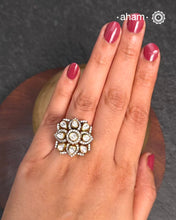 This exquisite ring features dazzling moissanite stones set within an elegant flower design. Crafted from 92.5% sterling silver and enhanced with a refined gold polish, for a luxurious finish. Perfect for those seeking a sophisticated blend of classic craftsmanship and contemporary style.
