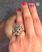 Crafted from 92.5% sterling silver with a rich gold polish, this ring showcases a captivating green emerald center stone. Surrounding it, moissanite stones add exceptional sparkle and brilliance, enhancing the ring’s luxurious appeal. Designed with precision, this piece offers a perfect blend of elegance and glamour for discerning jewellery enthusiasts.