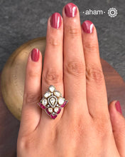 This exquisite ring features a dazzling moissanite stones set within an elegant design, accented by vibrant fuchsia pink stones. Crafted from 92.5% sterling silver and enhanced with a refined gold polish, for a luxurious finish. Perfect for those seeking a sophisticated blend of classic craftsmanship and contemporary style.