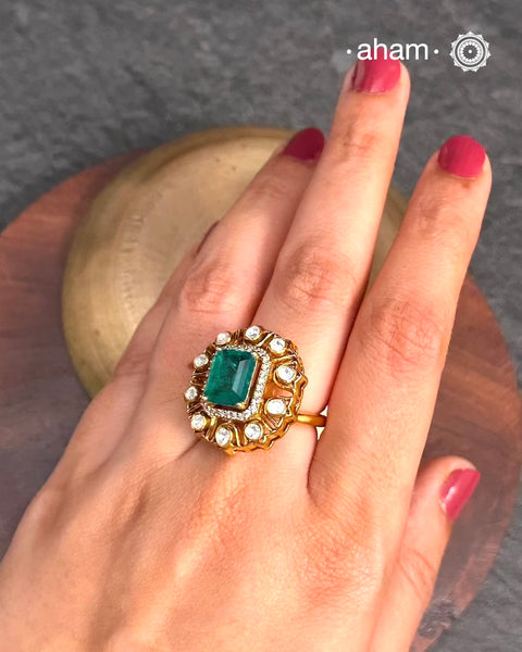 Crafted from 92.5% sterling silver with a rich gold polish, this ring showcases a captivating green emerald-like center stone. Surrounding it, moissanite stones add exceptional sparkle and brilliance, enhancing the ring’s luxurious appeal. Designed with precision, this piece offers a perfect blend of elegance and glamour for discerning jewellery enthusiasts.