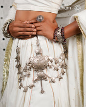 Rooted in the traditions of India's tribal communities, this handcrafted Silver Kamarbandh is a striking expression of heritage and craftsmanship. At its heart lies an intricately carved peacock motif, meticulously handcrafted using the traditional Chilai work technique, surrounded by hand-cut leaf motifs and cascading silver ghungroos. Every element comes together to create a piece that moves gracefully with every step.