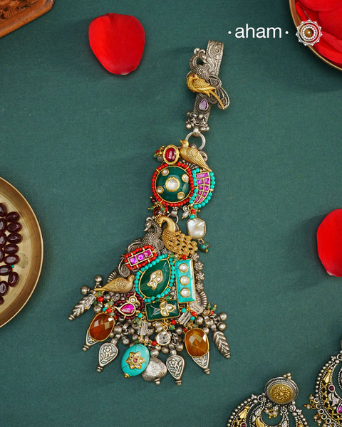 Challa/Juda/Chatka/ Guchha or waist key chains hold a special place in a woman’s trousseau, symbolizing tradition and elegance. The Noori Two Tone Silver Waist Key Ring features exquisite kundan work and carefully selected fine stones, all crafted in high-quality silver. This unique piece blends timeless craftsmanship with distinctive design, making it a meaningful accessory that complements your individuality.