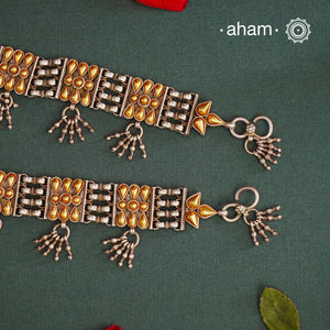 Enhance your style with the timeless elegance of the Dual Tone Silver anklets. Handcrafted by skilled karigars in Barmer, Rajasthan, this neckpiece features traditional Bandhel work, where a thin sheet of hand beaten&nbsp;22 carat gold is set on 92.5 silver using a unique wax setting technique. A classic representation of fine Indian traditional craftsmanship.