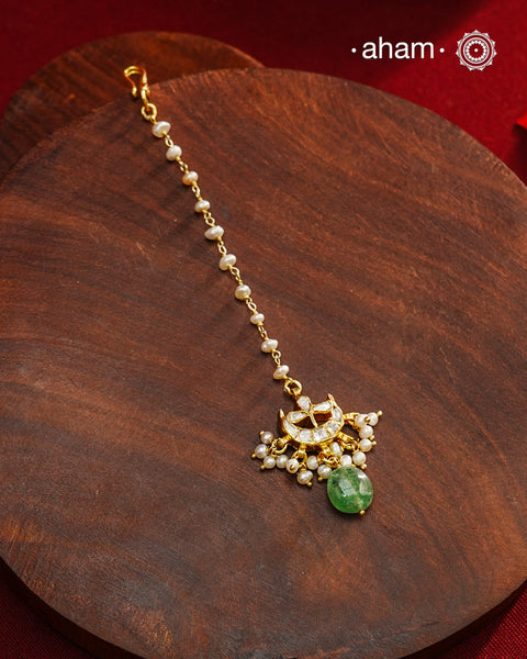 Crafted from 92.5% sterling silver with a fine gold polish finish, this maang tikka features brilliant moissanite stones that enhance its radiant appeal. Designed for enduring shine and elegance, it is an ideal accessory to complement your ensemble on special occasions.