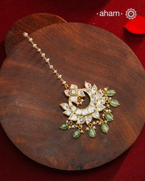 Crafted from 92.5% sterling silver with a fine gold polish finish, this maang tikka features brilliant moissanite stones that enhance its radiant appeal. Designed for enduring shine and elegance, it is an ideal accessory to complement your ensemble on special occasions.
