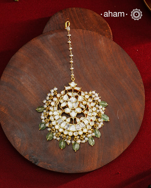 Crafted from 92.5% sterling silver with a fine gold polish finish, this maang tikka features brilliant moissanite stones that enhance its radiant appeal. Designed for enduring shine and elegance, it is an ideal accessory to complement your ensemble on special occasions.