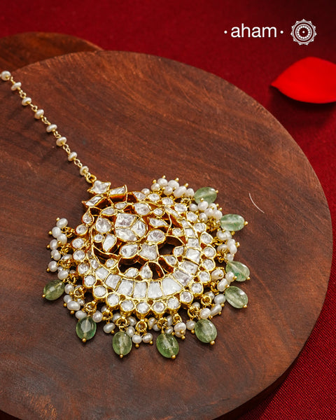Crafted from 92.5% sterling silver with a fine gold polish finish, this maang tikka features brilliant moissanite stones that enhance its radiant appeal. Designed for enduring shine and elegance, it is an ideal accessory to complement your ensemble on special occasions.