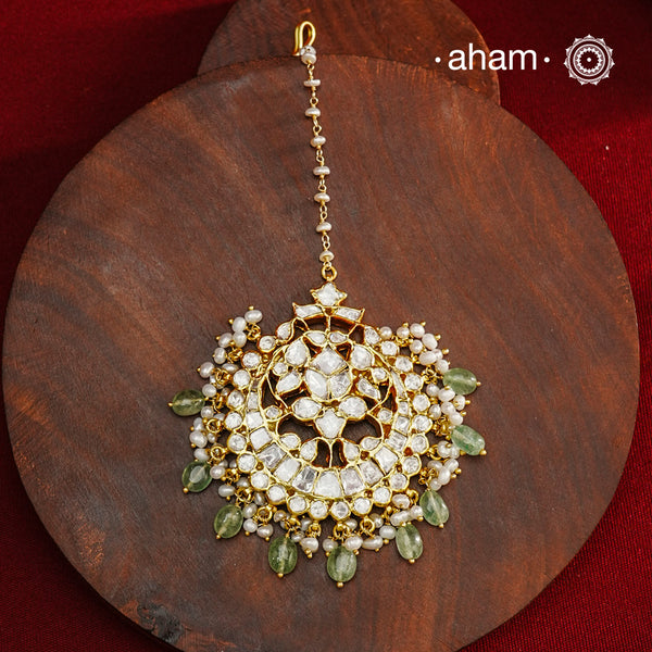 Crafted from 92.5% sterling silver with a fine gold polish finish, this maang tikka features brilliant moissanite stones that enhance its radiant appeal. Designed for enduring shine and elegance, it is an ideal accessory to complement your ensemble on special occasions.
