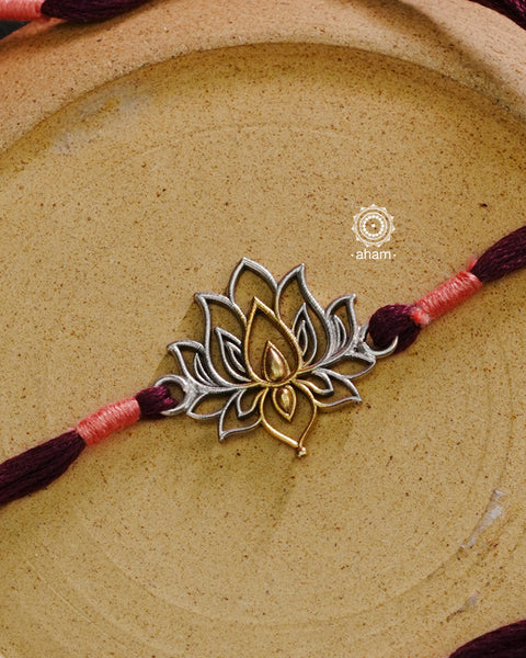 Make this Rakshabandhan memorable with this handcrafted silver Rakhi.Serene and beautiful Lotus Silver Rakhi in tones of gold and silver with cotton thread.
