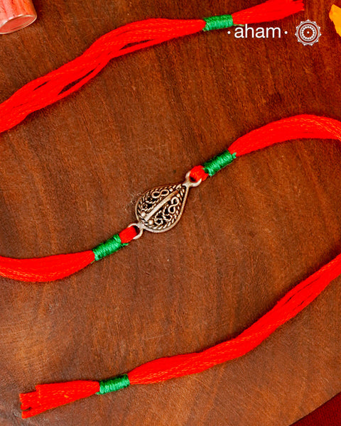 Beautiful Flower Rakhi crafted in silver.
Make this Rakshabandhan Memorable with this handcrafted Rakhi for an ever-lasting Knot and the&nbsp;Eternal protection of Lord Shiva.

Tip: you can later convert this into a key chain charm or a pendant as well

Roli and Akshat (kumkum chawal) shipped along with India orders only