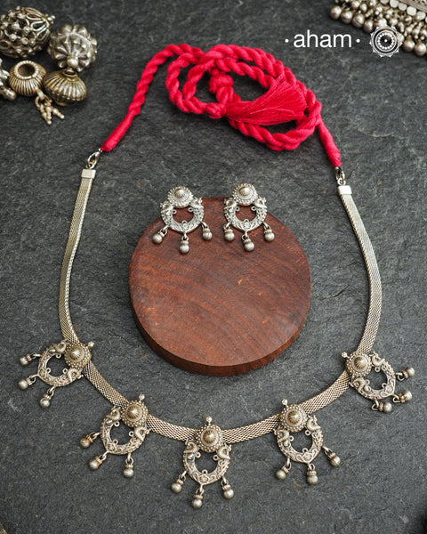 The Mewad Silver Neckpiece & Earrings Set showcases expertly crafted silver paired with delicate ghungroos, designed to complement professional attire effortlessly. This lightweight and elegant set brings a refined cultural touch to your workwear, ensuring comfort and sophisticated style throughout your busy day.