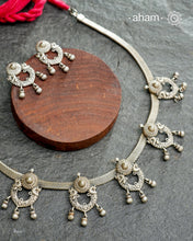 The Mewad Silver Neckpiece &amp; Earrings Set showcases expertly crafted silver paired with delicate ghungroos, designed to complement professional attire effortlessly. This lightweight and elegant set brings a refined cultural touch to your workwear, ensuring comfort and sophisticated style throughout your busy day.