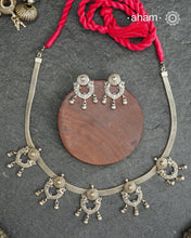 The Mewad Silver Neckpiece &amp; Earrings Set showcases expertly crafted silver paired with delicate ghungroos, designed to complement professional attire effortlessly. This lightweight and elegant set brings a refined cultural touch to your workwear, ensuring comfort and sophisticated style throughout your busy day.