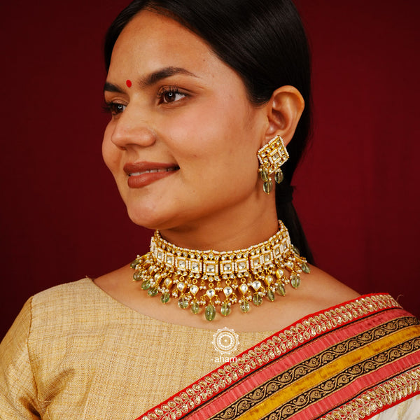 Elegant gold polish kundan choker set with embellished cultured pearls. Handcrafted using traditional jadua kundan techniques in 92.5 sterling silver with semi precious green beads. Perfect for intimate weddings and upcoming festive celebrations.