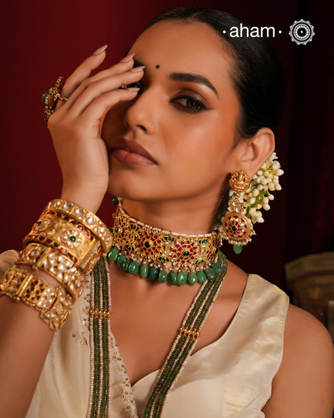 Make a sophisticated style statement this festive season with this floral choker set with semi precious green beads. Handcrafted using traditional kundan jadua techniques in 92.5 sterling silver with cultured pearls. The earrings have a intricate goddess Lakshmi motif. 