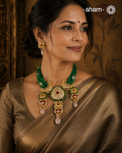Make a sophisticated style statement this festive season with our beautiful gold polish neckpiece and earrings set. Crafted using traditional jadau kundan techniques in silver with green semi precious beads and cultured pearls. Perfect for intimate weddings and upcoming festive celebrations.