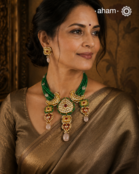 Make a sophisticated style statement this festive season with our beautiful gold polish neckpiece and earrings set. Crafted using traditional jadau kundan techniques in silver with green semi precious beads and cultured pearls. Perfect for intimate weddings and upcoming festive celebrations.