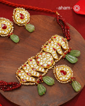 Make a sophisticated style statement this festive season with our beautiful gold polish neckpiece and earrings set. Crafted using traditional jadau kundan techniques in silver with green semi precious beads and cultured pearls. Perfect for intimate weddings and upcoming festive celebrations.