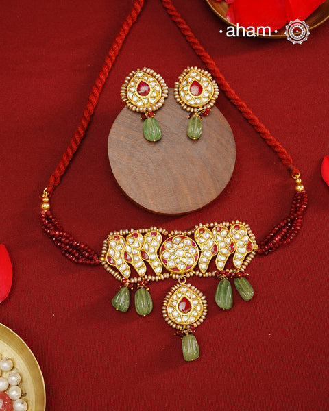 Make a sophisticated style statement this festive season with our beautiful gold polish neckpiece and earrings set. Crafted using traditional jadau kundan techniques in silver with green semi precious beads and cultured pearls. Perfect for intimate weddings and upcoming festive celebrations.