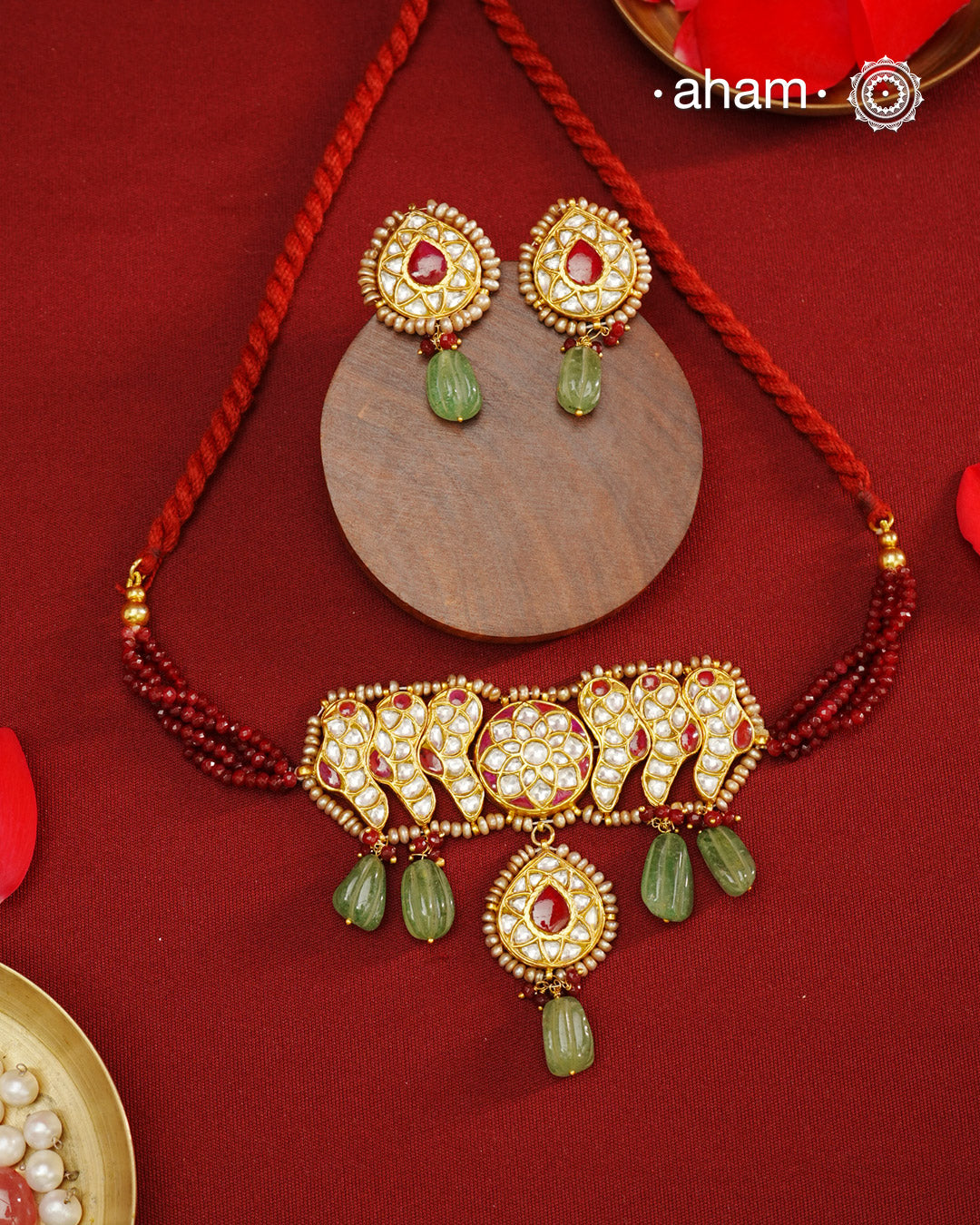 Make a sophisticated style statement this festive season with our beautiful gold polish neckpiece and earrings set. Crafted using traditional jadau kundan techniques in silver with green semi precious beads and cultured pearls. Perfect for intimate weddings and upcoming festive celebrations.