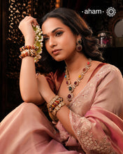 Crafted with expert precision, the Navratna Gold Polish Silver Neckpiece &amp; Earrings Set features a stunning combination of traditional design and modern elegance. Made with 92.5 silver and gold plating, this set showcases exquisite moissanite work. Elevate any outfit with this timeless and sophisticated accessory.