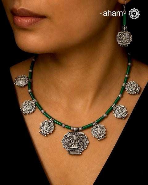 A beautiful neckpiece that we have made using vintage pieces that are inspired from Himalayan jewellery from the regions of nepal and tibet. 
The shapes are inspired from the mandala Ga'u forms with Intricate patterns,  and they are interspersed with malachite beads and small silver beads that have intricate detailing on them. The center pendant depicts Goddess Tara. 
Extremely fine workmanship and one of a kind piece. 