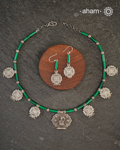 A beautiful neckpiece that we have made using vintage pieces that are inspired from Himalayan jewellery from the regions of nepal and tibet. 
The shapes are inspired from the mandala Ga'u forms with Intricate patterns,  and they are interspersed with malachite beads and small silver beads that have intricate detailing on them. The center pendant depicts Goddess Tara. 
Extremely fine workmanship and one of a kind piece. 