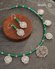 A beautiful neckpiece that we have made using vintage pieces that are inspired from Himalayan jewellery from the regions of nepal and tibet. 
The shapes are inspired from the mandala Ga'u forms with Intricate patterns,  and they are interspersed with malachite beads and small silver beads that have intricate detailing on them. The center pendant depicts Goddess Tara. 
Extremely fine workmanship and one of a kind piece. 