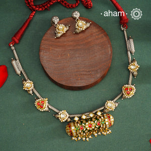 Expertly crafted in 92.5% silver, the Noori Dual Tone Silver Neckpiece &amp; Earrings Set blends traditional South Indian amulet design with contemporary elegance. Featuring intricate kemp work and gold polish at its center, the set is adorned with multiple small silver amulets along the chain and delicate pearl highlights. This dual-tone ensemble offers a refined balance of heritage and modernity, making it a timeless addition to any collection.