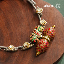 Expertly crafted in 92.5% silver, the Noori Dual Tone Silver Neckpiece &amp; Earrings Set blends traditional South Indian amulet design with contemporary elegance. Featuring intricate kemp work and gold polish at its center, the set is adorned with multiple small silver amulets along the chain and delicate pearl highlights. This dual-tone ensemble offers a refined balance of heritage and modernity, making it a timeless addition to any collection.