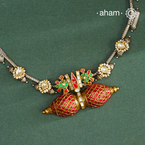 Expertly crafted in 92.5% silver, the Noori Dual Tone Silver Neckpiece &amp; Earrings Set blends traditional South Indian amulet design with contemporary elegance. Featuring intricate kemp work and gold polish at its center, the set is adorned with multiple small silver amulets along the chain and delicate pearl highlights. This dual-tone ensemble offers a refined balance of heritage and modernity, making it a timeless addition to any collection.