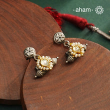 Expertly crafted in 92.5% silver, the Noori Dual Tone Silver Neckpiece &amp; Earrings Set blends traditional South Indian amulet design with contemporary elegance. Featuring intricate kemp work and gold polish at its center, the set is adorned with multiple small silver amulets along the chain and delicate pearl highlights. This dual-tone ensemble offers a refined balance of heritage and modernity, making it a timeless addition to any collection.