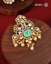 Crafted in 92.5 sterling silver with an elegant gold polish finish, this pendant and earring set features sparkling moissanite stones surrounding a lustrous green centre stone. Timeless yet striking, it is designed to add effortless sophistication to special occasions.