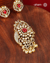 An exquisite composition of sparkling moissanites arranged around a vivid ruby-hued center, creating a pendant earring set that feels both timeless and striking. Crafted in 92.5 silver with gold polish, the piece draws inspiration from traditional Indian jewellery while remaining easy to style for modern celebrations.