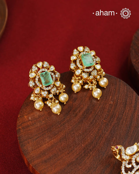 Crafted in 92.5 sterling silver with an elegant gold polish finish, this pendant and earring set features sparkling moissanite stones surrounding a lustrous green centre stone. Timeless yet striking, it is designed to add effortless sophistication to special occasions.